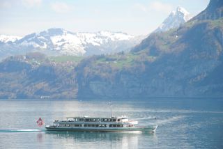 Schiff mit Schweizflagge vor Bergkulisse